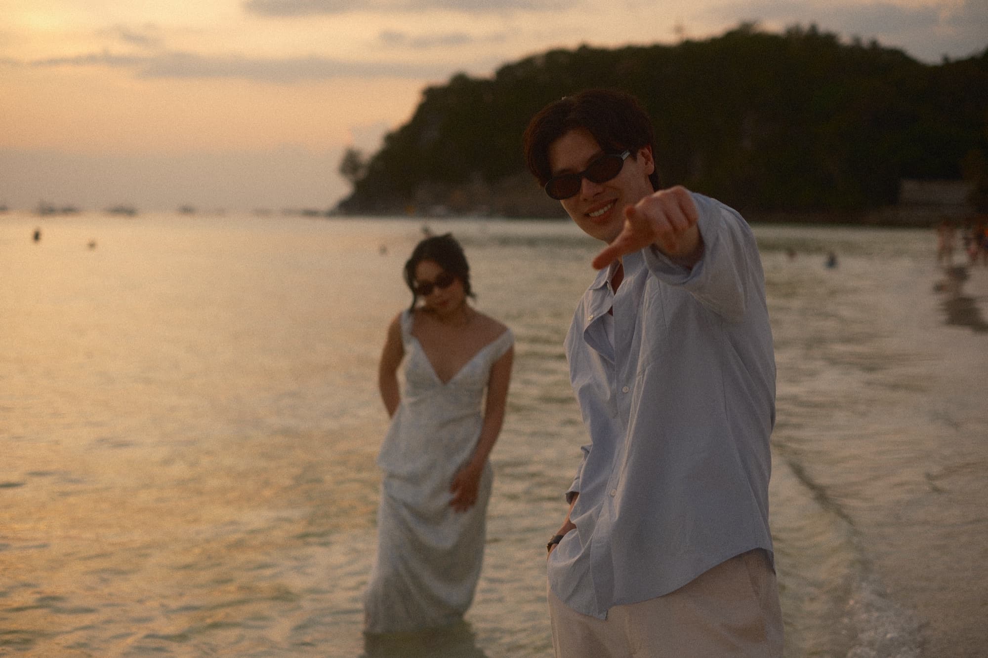 Couple standing in shallow water at sunset
