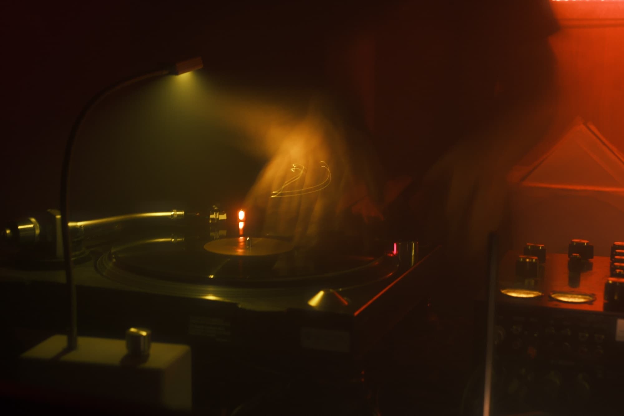 DJ performing under red stage lighting