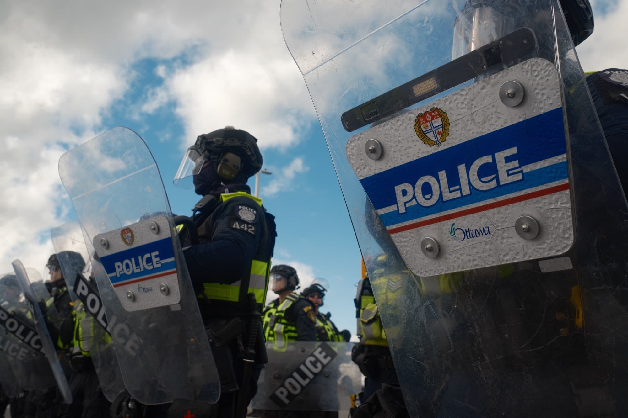 Police line at a protest against a cloudy sky